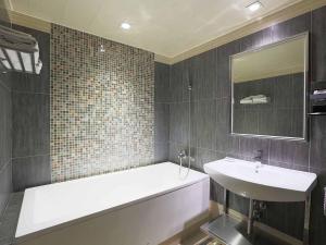 La salle de bains est pourvue d'une baignoire et d'un lavabo. dans l'établissement Royal Group Motel Buo Ai Branch, à Kaohsiung