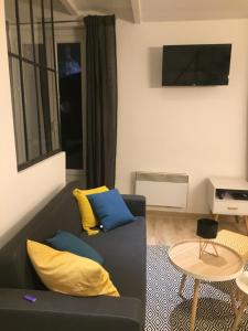 uma sala de estar com um sofá preto e almofadas amarelas em Soo Cathédrale SooHome em Marselha