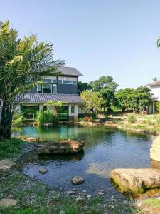 uma casa com um lago em frente a uma casa em 五柳園休閒農場-嘉義市民宿001號 em Chiayi