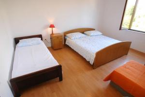 a bedroom with two beds and a night stand at Apartments Darinka in Sevid