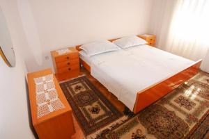 a bedroom with a bed with white sheets and rugs at Apartments Darinka in Sevid +27 photos