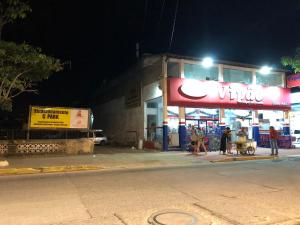 Un groupe de personnes marchant dans une rue la nuit dans l'établissement Hostel Beach, à Porto Seguro