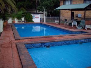 a large swimming pool with blue tiles on it at Banana Coast Caravan Park in Coffs Harbour