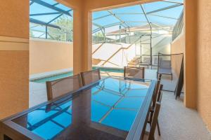 a glass table and chairs in a room with a pool at Townhouse in Paradise Palms, Kissimmee in Kissimmee