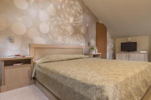 a bedroom with a large bed and a television at Effect Malina Residence Hotel in Pamporovo