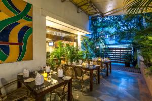 a restaurant with tables and chairs and plants at Hotel Park Central Koregaon Park in Pune