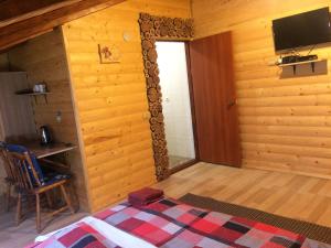 a room with a bed and a television in a cabin at Три берези in Yaremche