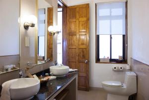 a bathroom with a sink, toilet and a mirror at Le Domaine de La Reserve in Baie Sainte Anne