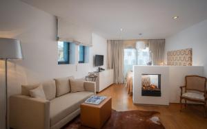 a living room with a couch and a fireplace at Hotel Bergkristall Oberlech in Lech am Arlberg