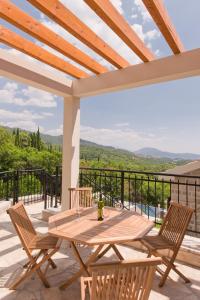 een houten tafel en stoelen op een patio met uitzicht bij Apartment Olivia in Herceg-Novi