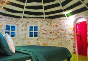 a room with a green couch and two windows at Phu Nam House - Resort in Phú Quốc