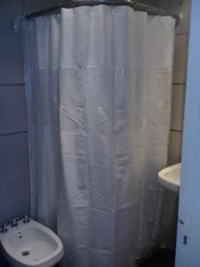 Un baño con una cortina de ducha blanca y un lavabo. en Apart Delacroix, en Santa Fe 15 fotos más