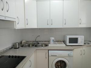 a kitchen with white cabinets and a sink and a dishwasher at Apartamento Maicandil in Ronda +19 photos
