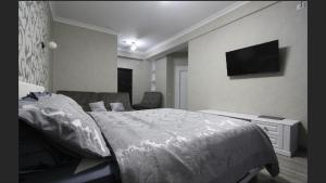 a bedroom with a bed and a tv on the wall at Apartment deluxe in Chişinău