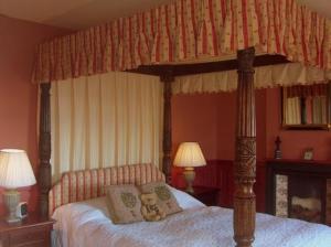 een slaapkamer met een hemelbed met teddyberen erop bij The Hunters Rest Inn in Clutton