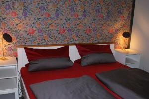 ゴスラーにあるFerienwohnung Goselagerの花の壁のベッドルーム1室(赤いベッド1台付)