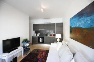 a living room with a white couch and a flat screen tv at Central Lisbon Luxury Apartment in Lisbon