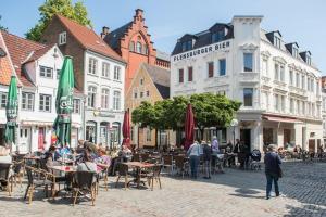 a group of people sitting at tables in a city street at Padborg Hotel in Padborg