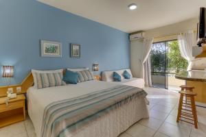 a bedroom with a large bed and a large window at Pousada Barra Mar in Barra de Ibiraquera