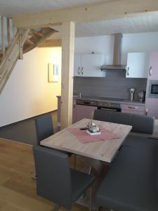 a kitchen with a wooden table and chairs and a kitchen with a counter at Ferienwohnung Lisa in Bad Mitterndorf