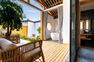 a wooden deck with a tub and a bath room at Su Xin Resort Inn in Zhangjiajie
