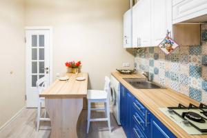 リヴィウにあるKulisha Cosy Apartmentのキッチン(青いキャビネット、木製カウンタートップ付)