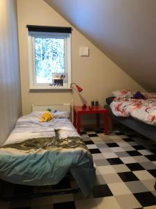 a attic room with two beds and a window at Persbyheden 14 in Sysslebäck