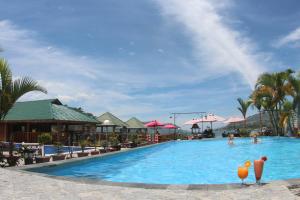 a pool at a resort with people in it at Toba Village Inn in Tuktuk Siadong