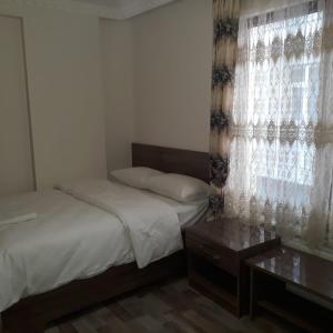 a small bedroom with a bed and a window at Toprak Hotel in Van