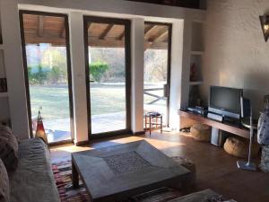 sala de estar con sofá, TV y puertas correderas de cristal en The Refuge, en Bachevo