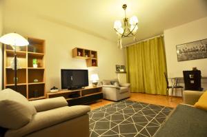 ein Wohnzimmer mit einem Sofa und einem TV in der Unterkunft Młociny Metro Apartment in Warschau