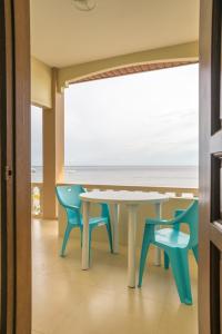 una mesa y sillas en una habitación con vistas al océano en Kellocks' Seaview Apartelle en Dalaguete