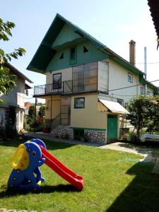 a childs toy in the grass in front of a house at Casa Verde in Săsciori