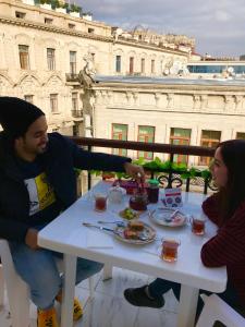 Um homem e uma mulher sentados à mesa com comida. em Fountain Square-Balconies in Old Town em Baku