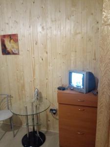 Cette chambre dispose d'une table et d'une télévision sur une commode. dans l'établissement Apartment on Stepana Bandery 37 Постійне електропостачання, à Lviv