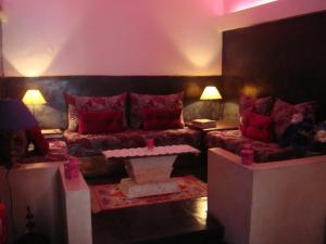 Riad La Villa & Spa في الجديدة: غرفة معيشة مع أريكة وطاولة