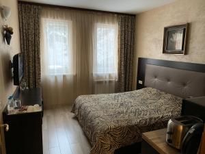 a hotel room with a bed and a window at Apartments & Rooms Royal Plaza in Borovets