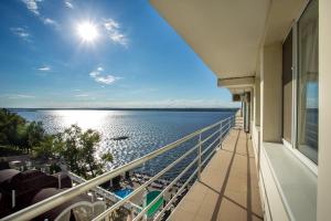 a balcony with a view of the water at Optima River Mykolaiv in Mykolaiv