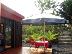a table and chair under an umbrella on a patio at Casa Sandra en Las Norias Todoque con Wi-Fi in Los Llanos de Aridane