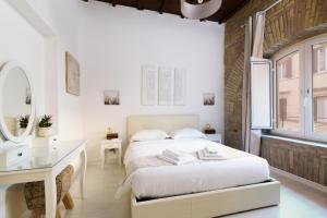 una camera con letto, scrivania e specchio di White Ostilia Apartments a Roma