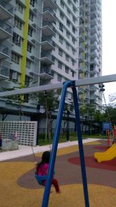 a little girl playing on a swing in a playground at Mintsuite homestay in Putrajaya
