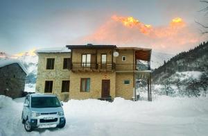 a car parked in front of a house in the snow at Peak Mazeri Guest House in Mazeri +36 photos