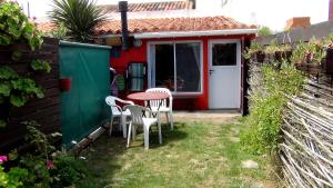 un patio con mesa y sillas frente a una casa en Complejo la Cuevita en Mar del Sur