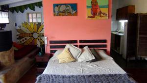 Un dormitorio con una cama y una pared rosa. en Complejo la Cuevita, en Mar del Sur