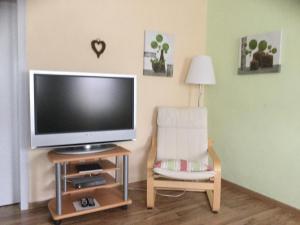ein Wohnzimmer mit einem TV und einem Stuhl in der Unterkunft Ferienhaus Weins in Lieg