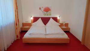 a bed with white sheets and pillows in a room at Appartements Dornach in Schenna
