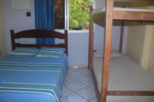 two bunk beds in a room with a window at Pousada Recanto Setiba in Guarapari