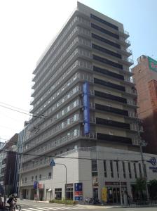 Un edificio alto con una señal azul. en Daiwa Roynet Hotel Osaka-Uehonmachi, en Osaka