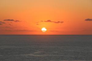 una puesta de sol sobre el océano con el sol en el cielo en Dammuso Villa Giò, en Pantelleria