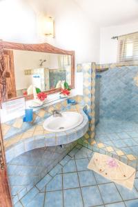 a bathroom with a sink and a mirror at Villas Kalimba in Sámara